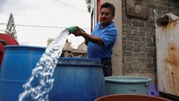 Ekspresi salah satu warga yang senang saat mendapatkan air bersih.