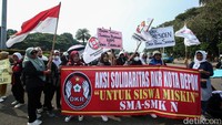 Massa menggelar aksi dengan membawa berbagai poster dan spanduk.