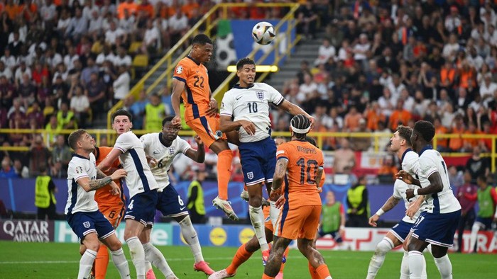 Belanda vs Inggris DORTMUND, GERMANY - JULY 10: Denzel Dumfries of the Netherlands has a headed shot whilst under pressure from Jude Bellingham of England, which hits the crossbar, during the UEFA EURO 2024 semi-final match between Netherlands and England at Football Stadium Dortmund on July 10, 2024 in Dortmund, Germany. (Photo by Dan Mullan/Getty Images)
