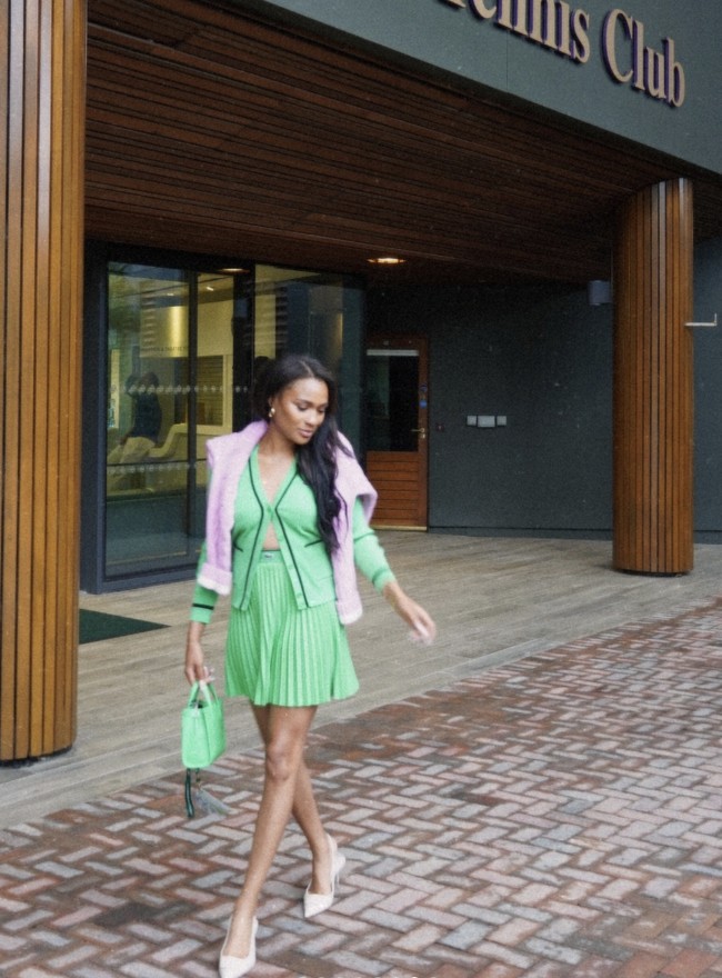 Inilah Ayan Broomfield, pacar bintang tenis AS Frances Tiafoe, yang juga seorang atlet tenis. Saat mendukung sang kekasih, perempuan 26 tahun itu memakai cardigan tanpa bra sehingga mempertegas aura seksinya. Atasan tersebut dipasangkan dengan rok plisket yang feminin. Tas hijau senada juga andalan. Sementara itu sweater pink menjaga gayanya tak monoton. (Foto: Instagram/@ayan.broomfield)