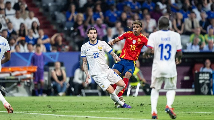 MUNICH, GERMANY - JULY 09: Lamine Yamal of Spain is tackled by Theo Hernandez of France (L) during the UEFA EURO 2024 semi-final match between Spain v France at Munich Football Arena on July 09, 2024 in Munich, Germany. (Photo by Markus Gilliar - GES Sportfoto/Getty Images)