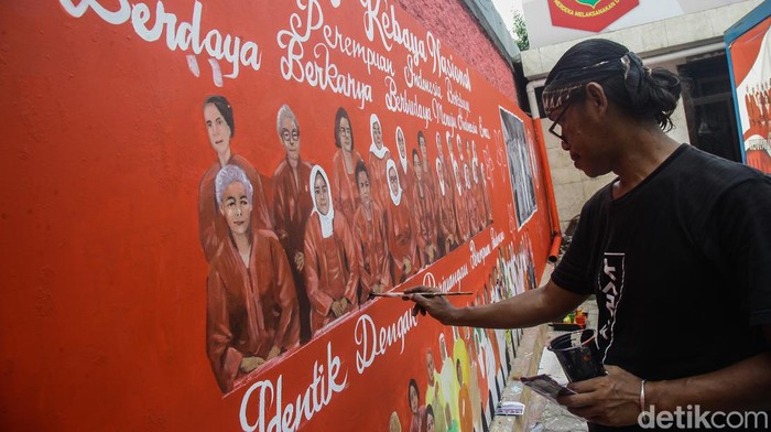 Membuat Mural Sambut Hari Kebaya Nasional Seniman Iwan Widodo menggambar mural di Jl Imam Bonjol, Jakarta, Kamis (11/7/2024). Mural ini dibuat untuk menyambut Hari Kebaya Nasional.