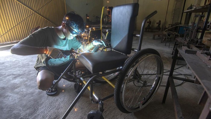 Perajin di Sukoharjo Produksi Kursi Roda Adaptif Standar WHO Pekerja memotong besi saat membuat kerangka kursi roda di Pusat Riset dan Inovasi Alat Disabilitas Pranatas, Makamhaji, Kartasura, Sukoharjo, Jawa Tengah, Kamis (11/7/2024). Kursi roda adaptif yang diproduksi dengan memenuhi delapan langkah layanan standar organisasi kesehatan dunia (WHO) dan menggunakan bahan-bahan Standar Nasional Indonesia (SNI) itu dijual dengan harga Rp5 juta hingga Rp9,5 juta per buah yang digunakan untuk pasien berkebutuhan khusus sehingga mudah digunakan dan perawatannya. ANTARA FOTO/Aloysius Jarot Nugroho/nym.