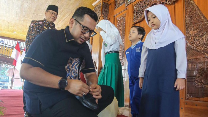 PJ Wali Kota Mojokerto Ali Kuncoro berikan sepasang sepatu dan seragam gratis kepada salah satu siswi SD.