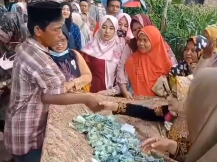 Unik tradisi pernikahan di Demak, tamu berikan sumbangan uang tanpa amplop dalam kain jarik pada pengantin.