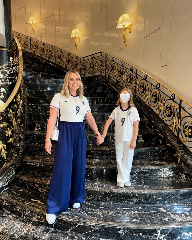 Istri Harry Kane, Kate, cukup sering membagikan gayanya saat menemani suami bertanding bola. Saat menonton laga Euro 2024 beberapa waktu lalu, ia memadukan jersey putih dengan nomor punggung suami dengan celana biru tua dan tas Chanel. Foto: Instagram @katekanex