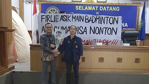 Wakil Ketua BEM Unud, Ricardo Contantio Elim (kanan) memberikan hadiah raket kepada Analis Tindak Pidana Korupsi KPK Denny Setiyanto sebagai bentuk kritikan kepada Firli Bahuri, Kamis (11/7/2024).