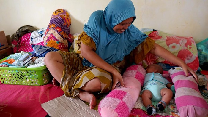Korban banjir mengungsi bersama anaknya di pos kantor Camat Tilango, Kabupaten Gorontalo, Gorontalo, Jumat (12/7/2024). Pemerintah daerah setempat mencatat 1.668 warga Kecamatan Tilango mengungsi akibat banjir luapan Danau Limboto, Sungai Tapodu dan Bulango. ANTARA FOTO/Adiwinata Solihin/aww.