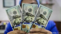 Petugas menunjukkan pecahan mata uang dolar AS di penukaran uang di Melawai, Jakarta Selatan, Jumat (12/7/2024).