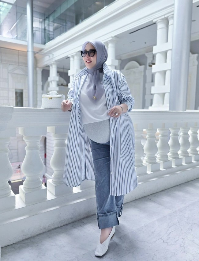 Syahrini tampil stylish dengan celana jeans palazzo dan blouse polos warna putih. Ia tampaknya mengenakan celana jeans khusus ibu hamil sehingga perut besarnya tetap nyaman selama beraktivitas. Foto: Instagram @princessyahrini