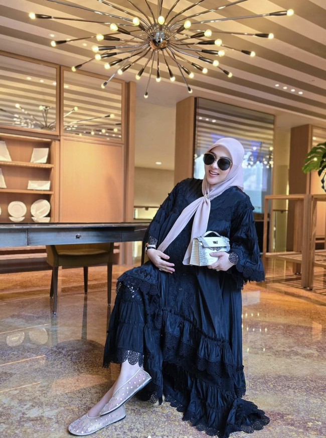 Syahrini terlihat nyaman saat mengenakan dress hitam dengan detail layering yang anggun. Pilihan sepatu flat memang paling nyaman untuk ibu hamil terutama ketika kandungan sudah matang. Foto: Instagram @princessyahrini