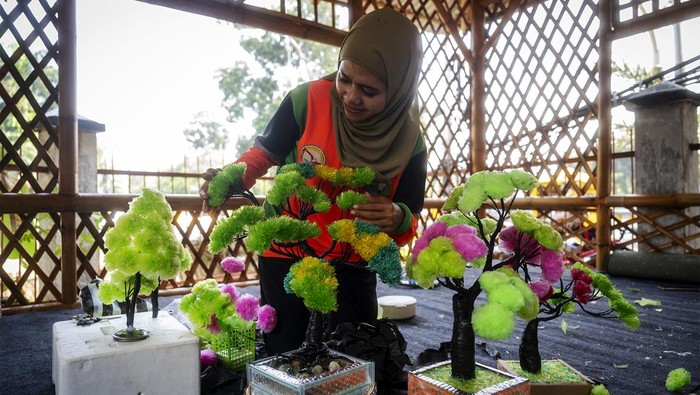 Petugas Unit Penanganan Sampah Badan Air Gambir meyelesaikan pembuatan tanaman hias dari limbah plastik di Gambir, Jakarta, Jumat (12/7/2024). Kreasi pembuatan daur ulang tanaman hias plastik tersebut terbuat dari limbah plastik yang ditemukan di aliran sungai. ANTARA FOTO/Erlangga Bregas Prakoso/foc.