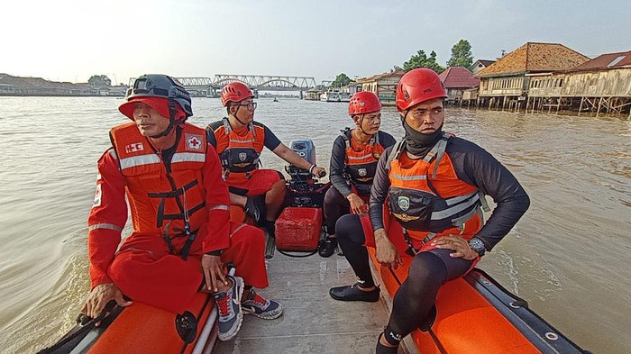 Petugas melakukan pencarian terhadap warga yang hilang usai terpeleset dari jembatan ogan