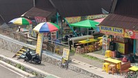 Saat mengelilingi kawasan rest area, terlihat banyak lapak-lapak dagangan yang belum buka dengan rolling door tertutup rapat. Di depan lapak yang belum buka ini juga tidak terlihat ada spanduk, gerobak/etalase atau tempat duduk yang menandakan lapak ini belum ada penghuninya. Foto: Ignacio Geordy Oswaldo