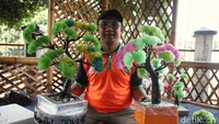 Petugas UPS Badan Air Kecamatan Gambir menunjukan bunga plastik hasil karya mereka, Jumat (12/7/2024).