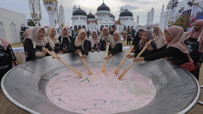 Sejumlah warga Banda Aceh mengaduk bubur asyura saat pencatatan rekor Museum Rekor Dunia Indonesia (MURI) belanga terbesar dalam Sambot Muharram Raya di Masjid Raya Baiturrahman, Banda Aceh, Aceh, Sabtu (13/7/2024). Pencatatan rekor MURI memasak bubur asyura dengan belanga terbesar ukuran 2,6 meter x 2,6 meter tersebut merupakan rangkaian kegiatan Sambot Muharram Raya yang digelar Bank Indonesia Aceh dengan melibatkan masyarakat, sebagai upaya melestarikan tradisi yang dilakukan setiap menyambut bulan Muharram. ANTARA FOTO/Khalis Surry/Spt.