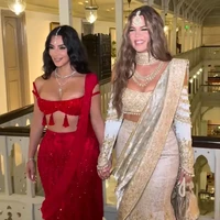 Kim Kardashian dan Khloe Kardashian tampil seksi dengan busana lehenga yang telah dimodifikasi jadi lebih kekinian. Namun penampilan Kim menuai kritik, ia dianggap melanggar tradisi di India karena memakai busana merah. Dalam upacara pernikahan Hindu modern, warna merah secara tradisional hanya dipakai oleh pengantin wanita. Foto: Dok. Instagram Kim Kardashian