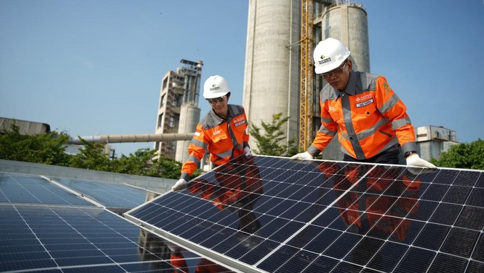 Karyawan PT Solusi Bangun Indonesia Tbk (SBI) melakukan instalasi solar panel di atap gedung utama kantor SBI Pabrik Tuban, Jawa Timur, sebagai upaya akselerasi transisi energi menuju energi baru terbarukan (EBT).