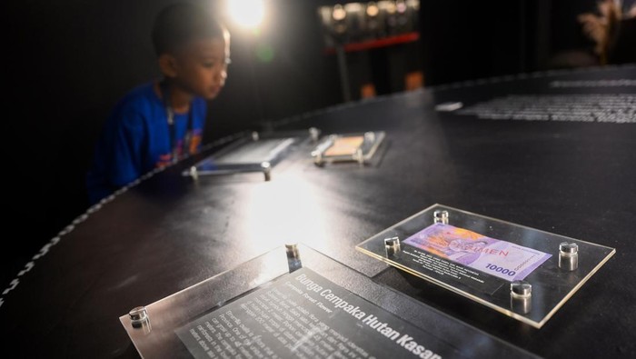 Pengunjung melihat pameran Temporer D'Commentry bertajuk Rupiah Berkisah Tentang Timur di Museum Bank Indonesia, Jakarta, Jumat (12/7/2024). Pameran tersebut memamerkan keberagaman sejarah, budaya dan lanskap timur Indonesia yang terekam dalam pecahan rupiah dari masa ke masa. ANTARA FOTO/Rivan Awal Lingga/foc.