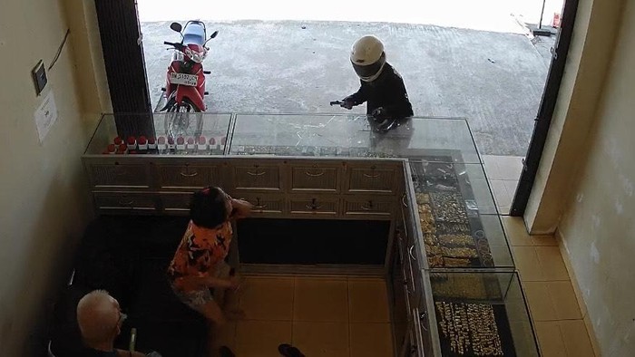 Perampok toko emas saat beraksi memecahkan kaca dan mengancam korbannya dengan senpi