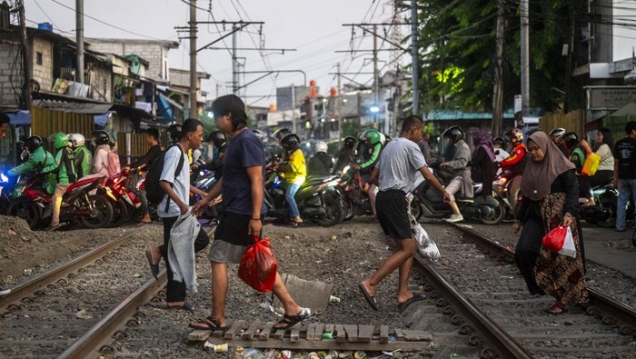 Perlintasan Sebidang Kereta Api di Roxy Bakal Ditutup Sejumlah warga dan pengendara sepeda motor melintasi perlintasan sebidang kereta api kawasan Roxy, Jakarta Pusat, Jumat (12/7/2024). Pemkot Jakarta Pusat mengkaji penutupan perlintasan sebidang di kawasan tersebut untuk pejalan kaki dan kendaraan bermotor karena rawan kecelakaan, sementara itu berdasarkan data dari PT Kereta Api Indonesia (Persero) sejak awal tahun 2024 tercatat telah terjadi 195 kali kecelakaan lalu lintas di perlintasan sebidang yang mengakibatkan 68 orang meninggal dunia. ANTARA FOTO/Erlangga Bregas Prakoso/nym.