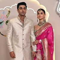 Aktris Alia Bhatt dan suaminya aktor Ranbir Kapoor tak ketinggalan jadi tamu undangan. Alia tampil dengan busana tradisional berupa lehenga dan kain saree. Brgitu pula Ranbir yang memakai setelan Sherwani. Foto: Getty Images