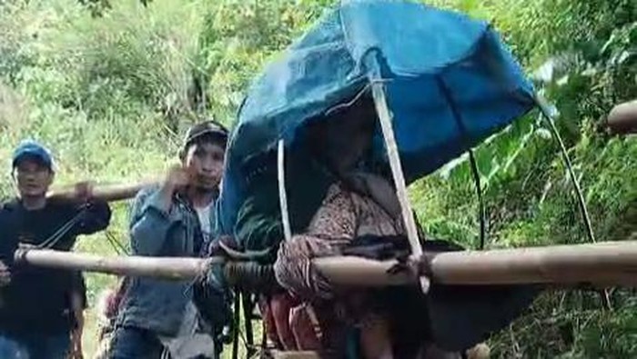 Warga sakit di Mamuju ditandu gegara akses jalan rusak.