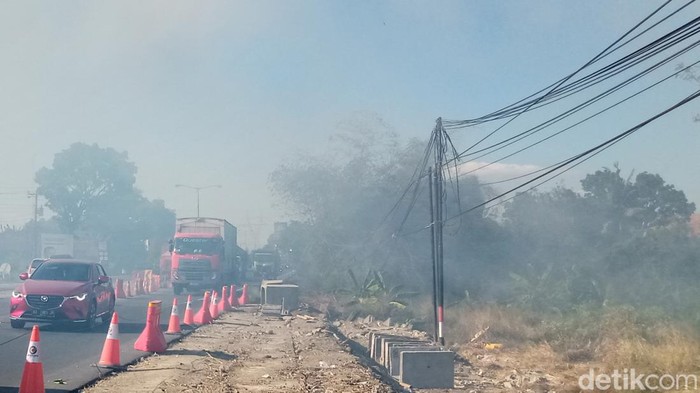 Asap lebakaran semak mengganggu jalan depan exit tol Kuncen, Kecamatan Ceper, Klaten, Minggu (14/7/2024) sore.