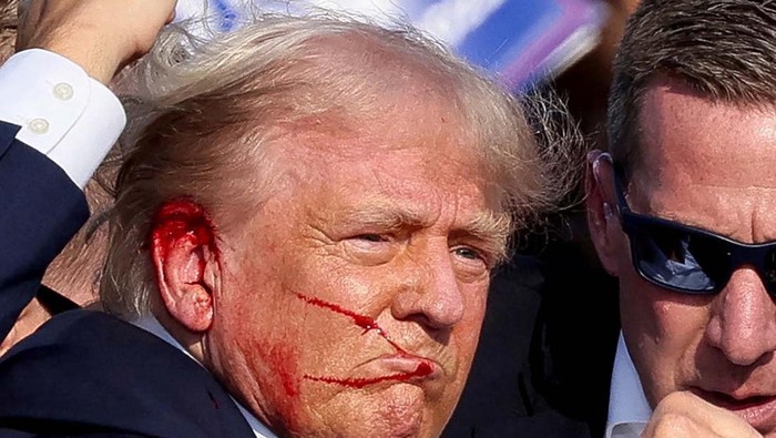 Republican presidential candidate and former U.S. President Donald Trump is assisted by the Secret Service after gunfire rang out during a campaign rally at the Butler Farm Show in Butler, Pennsylvania, U.S., July 13, 2024. REUTERS/Brendan McDermid