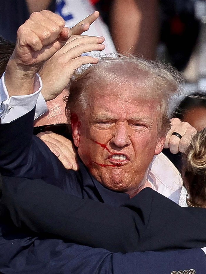Republican presidential candidate and former U.S. President Donald Trump is assisted by the Secret Service after gunfire rang out during a campaign rally at the Butler Farm Show in Butler, Pennsylvania, U.S., July 13, 2024. REUTERS/Brendan McDermid