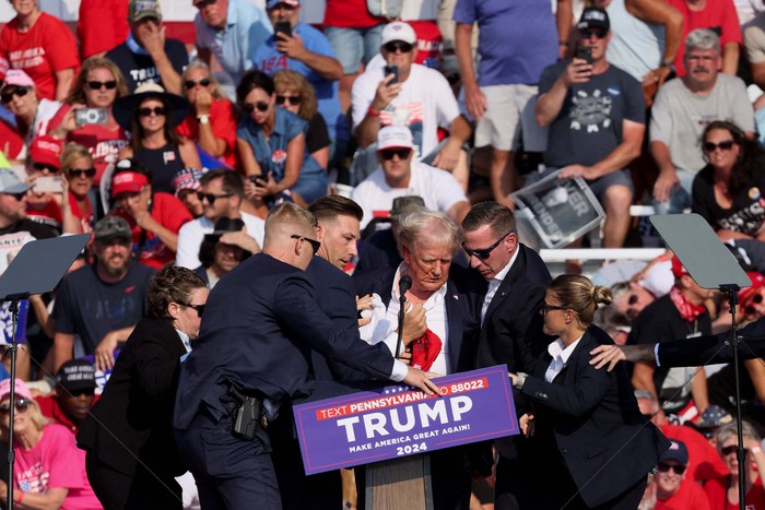 Republican presidential candidate and former U.S. President Donald Trump is assisted by the Secret Service after gunfire rang out during a campaign rally at the Butler Farm Show in Butler, Pennsylvania, U.S., July 13, 2024. REUTERS/Brendan McDermid