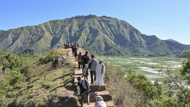 Sejumlah pengunjung memotret panorama bukit Selong dengan kamera gawainya di Sembalun, Kecamatan Sembalun, Lombok Timur, NTB, Minggu (14/7/2024). Wisatawan yang berkunjung ke objek wisata bukit Selong di kaki Gunung Rinjani tersebut dikenakan tiket masuk Rp5 ribu per orang untuk menikmati wisata alam dengan panorama perbukitan dan hamparan ladang. ANTARA FOTO/Ahmad Subaidi/nym.