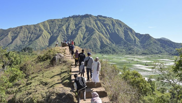 Cantiknya Wisata Bukit Selong Sembalun di Kaki Gunung Rinjani Sejumlah pengunjung memotret panorama bukit Selong dengan kamera gawainya di Sembalun, Kecamatan Sembalun, Lombok Timur, NTB, Minggu (14/7/2024). Wisatawan yang berkunjung ke objek wisata bukit Selong di kaki Gunung Rinjani tersebut dikenakan tiket masuk Rp5 ribu per orang untuk menikmati wisata alam dengan panorama perbukitan dan hamparan ladang. ANTARA FOTO/Ahmad Subaidi/nym.