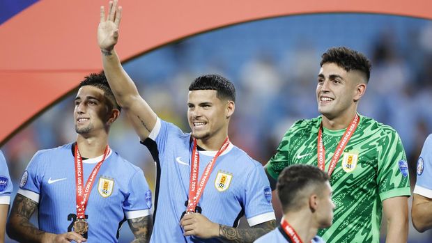 Uruguay's Maximiliano Araujo waves to fans after beating Canada in a penalty shootout during the Copa America third place soccer match in Charlotte, N.C., Saturday, July 13, 2024. (AP Photo/Nell Redmond)