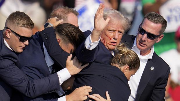 Republican presidential candidate former President Donald Trump is helped off the stage by U.S. Secret Service agents at a campaign event in Butler, Pa., on Saturday, July 13, 2024. (AP Photo/Gene J. Puskar)