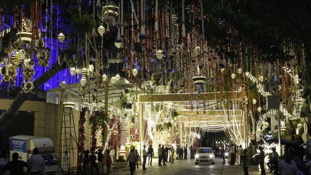 FILE - People walk past the Antilia mansion, house of billionaire Mukesh Ambani, while it is lit up ahead of his son Anant Ambani and Radhika Merchant's wedding in Mumbai, India, Wednesday, July 10, 2024. The youngest son of Mukesh Ambani, Asia’s richest man, has married his longtime girlfriend in what many have dubbed the wedding of the year. The wedding early Saturday was being attended by global celebrities, business tycoons and politicians, highlighting the billionaire’s staggering wealth and rising clout, and came after months of festivities.(AP Photo/Rajanish Kakade, File)