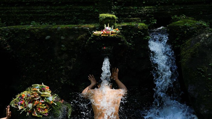 Melihat Umat Hindu Membersihkan Diri dalam Ritual Banyu Pinaruh A Balinese Hindu man takes part during a cleansing ritual called Banyu Pinaruh, which is believed to purify body and soul, at Mengening temple holy spring in Gianyar, Bali, Indonesia, July 14, 2024. REUTERS/Johannes P. Christo