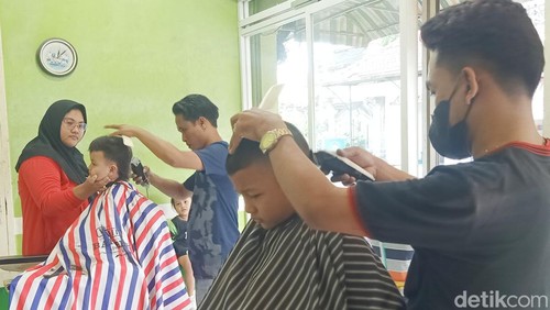 Salah satu tempat potong rambut yang ramai didatangi anak-anak sekolah terlihat di Matrik, Jalan Kembang Matahari, Denpasar, Bali, Minggu (14/7/2024). (Foto: Ni Made Lastri Karsiani Putri/detikBali)