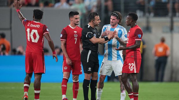 Jul 9, 2024; East Rutherford, NJ, USA; Canada midfielder Richie Laryea (22) talks with referee Piero Maza in front of Argentina midfielder Rodrigo De Paul (7) and midfielder Stephen Eustaquio (7) and forward Jonathan David (10) during the second half at Metlife Stadium. Mandatory Credit: Vincent Carchietta-USA TODAY Sports