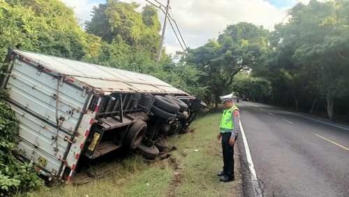 Sebuah truk boks terperosok ke parit di Jalan Raya Denpasar-Gilimanuk Km 124-125, Minggu (14/7/2024).