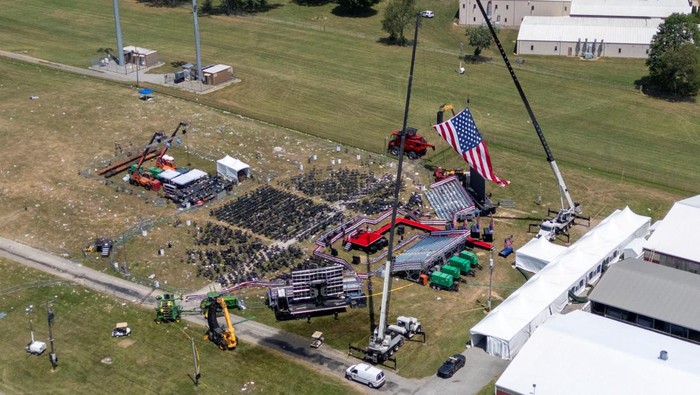 FBI Investigasi Lokasi Penembakan Donald Trump Saat Kampanye A drone view shows the stage where Republican presidential candidate and former U.S. President Donald Trump had been standing during an assassination attempt the day before, and the roof of a nearby building where a gunman was shot dead by law enforcement, in Butler, Pennsylvania, U.S. July 14, 2024. REUTERS/Carlos Osorio