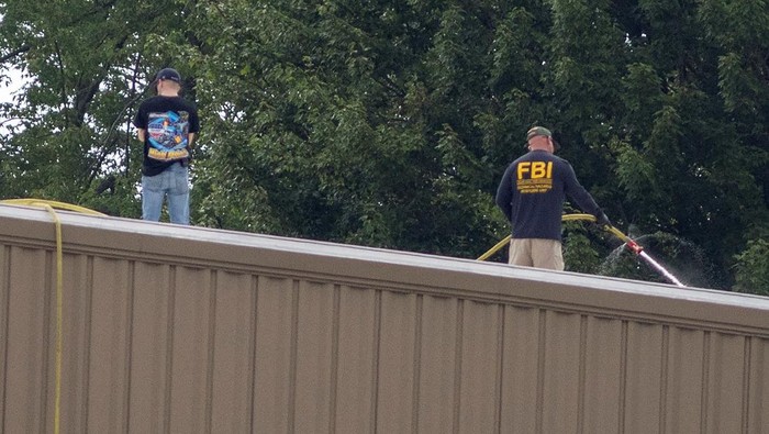 FBI Investigasi Lokasi Penembakan Donald Trump Saat Kampanye A drone view shows the stage where Republican presidential candidate and former U.S. President Donald Trump had been standing during an assassination attempt the day before, and the roof of a nearby building where a gunman was shot dead by law enforcement, in Butler, Pennsylvania, U.S. July 14, 2024. REUTERS/Carlos Osorio