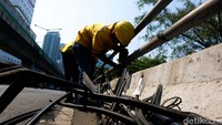 Petugas Bina Marga dan JakPro memotong kabel semrawut di Flyover Tendean, Jakarta, Senin (15/7/2024).  