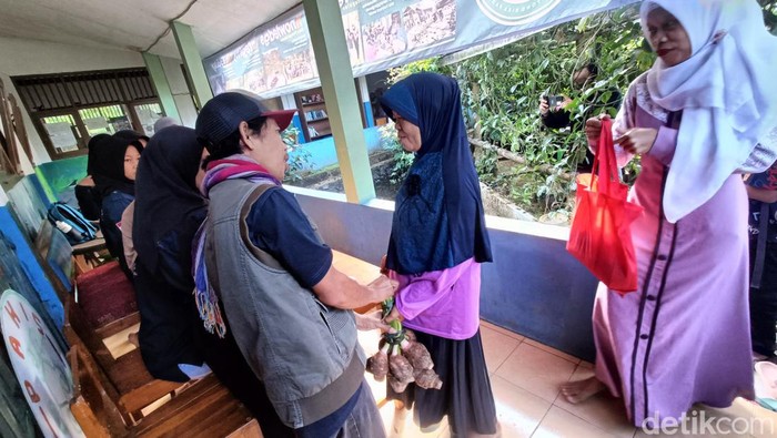 Wali murid membawa hasil bumi untuk mendaftarkan anaknya sekolah di MTs Pakis Gunung Lurah, Kecamatan Cilongok, Kabupaten Banyumas, Senin (15/7/2024).