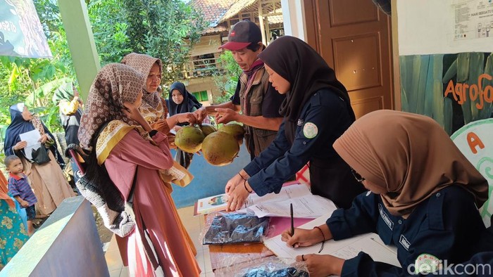 Wali murid membawa hasil bumi untuk mendaftarkan anaknya sekolah di MTs Pakis Gunung Lurah, Kecamatan Cilongok, Kabupaten Banyumas, Senin (15/7/2024).