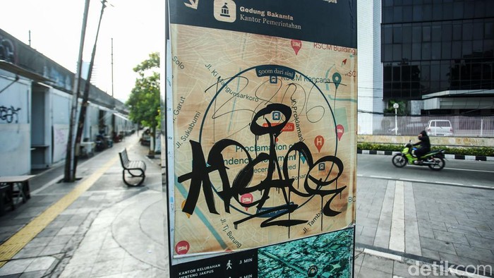 Papan Informasi Jaklingko Kena Vandalisme Pengendara melintas di Kawasan Menteng, Jakarta, Senin (15/7/2024). Sejumlah papan informasi nampak rusak terkena vandalisme. Aksi vandalisme ini membuat papan informasi menjadi tak terbaca.