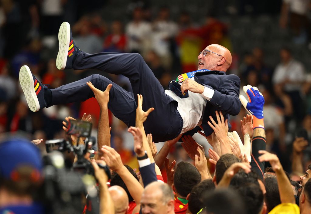 Pelatih Spanyol Luis de la Fuente dilempar ke udara oleh para pemainnya saat mereka merayakan kemenangan. Pelatih Spanyol Luis de la Fuente dilempar ke udara oleh para pemainnya saat mereka merayakan kemenangan. (REUTERS/Kai Pfaffenbach)