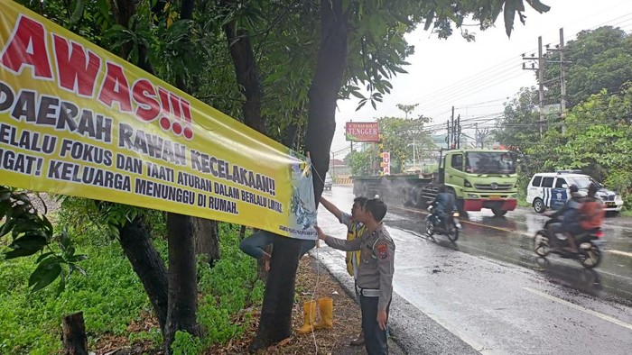 Pemasangan banner peringatan kecelakaan di Pasuruan.