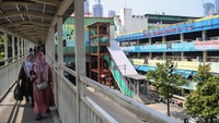 Warga berjalan di seberang gedung blok G Pasar Tanah Abang di Jakarta, Senin (15/7/2024).