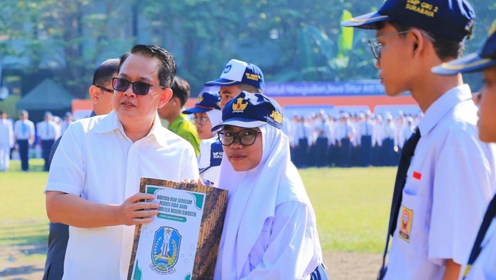 Pj Gubernur Jatim Adhy Karyono memberikan seragam gratis kepada perwakilan siswa SMA tak mampu di Jatim.